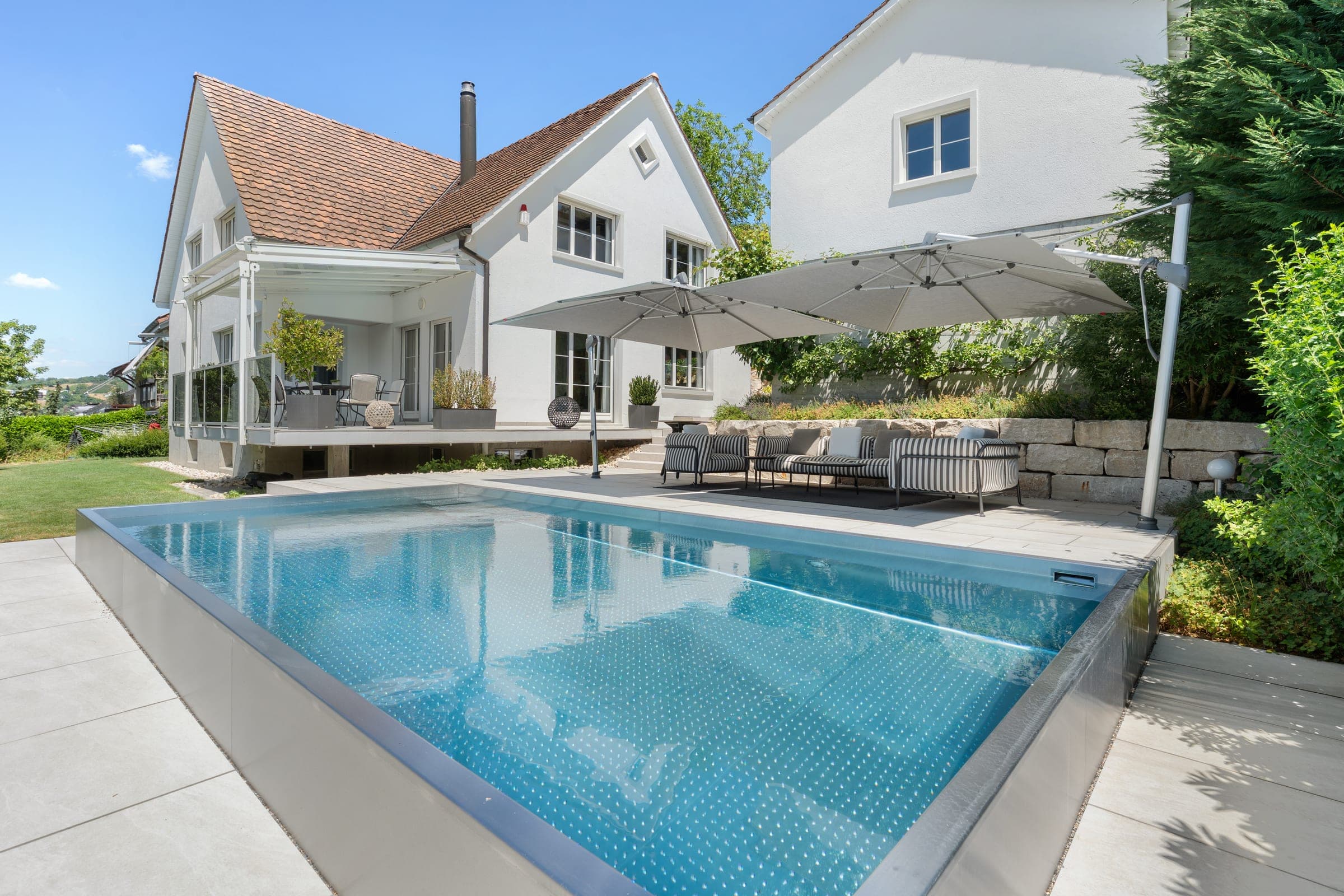 Haus mit Pool und Terrasse an einem sonnigen Tag