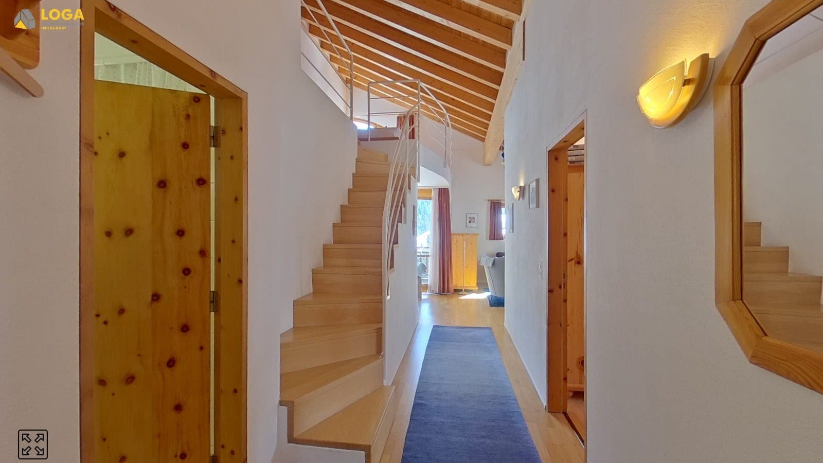 Eingangsbereich einer Wohnung mit Holztreppe und sichtbaren Balken