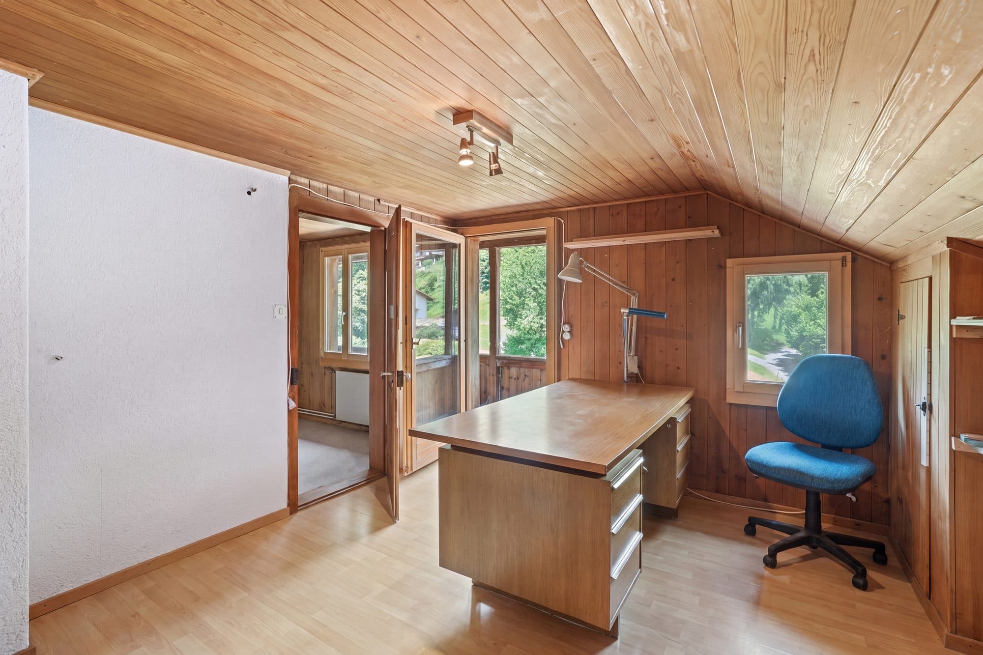 Dachzimmer voller Gegenstände und Kartons und dasselbe Zimmer aufgeräumt mit Schreibtisch und Stuhl